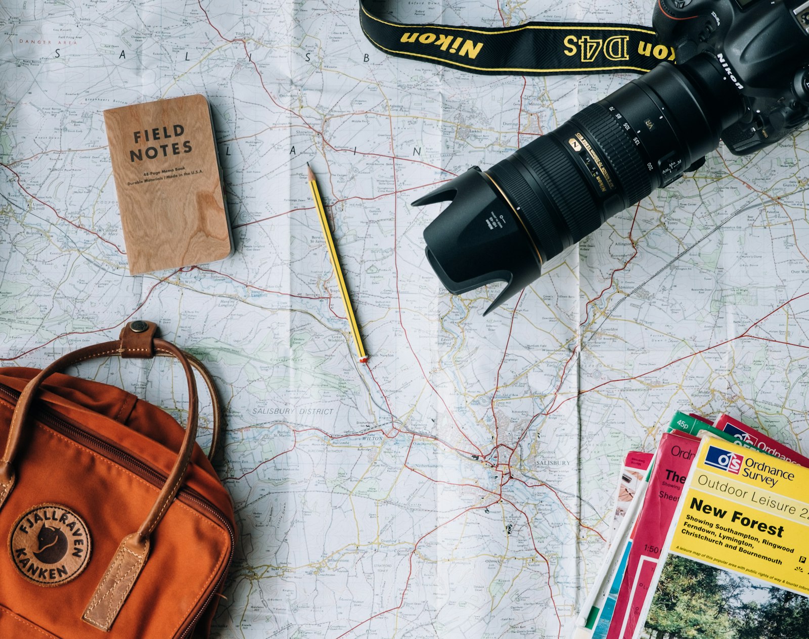 Open passport, world map, and travel notebook on a desk